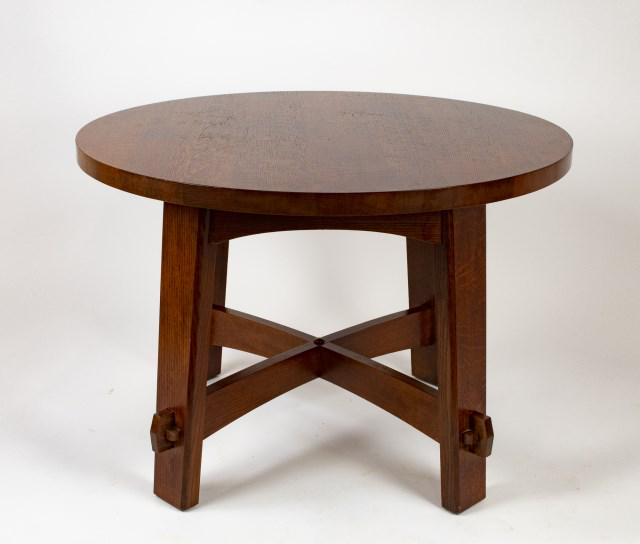 Stickley Audi Arts & Crafts Style Library Table: No. 89-407, oak library table with round top, canted legs having keyed tenons and connected by arched stretchers, branded mark and metal tag; 42" dia., 29 1/2"H; good condition with minor abrasions co