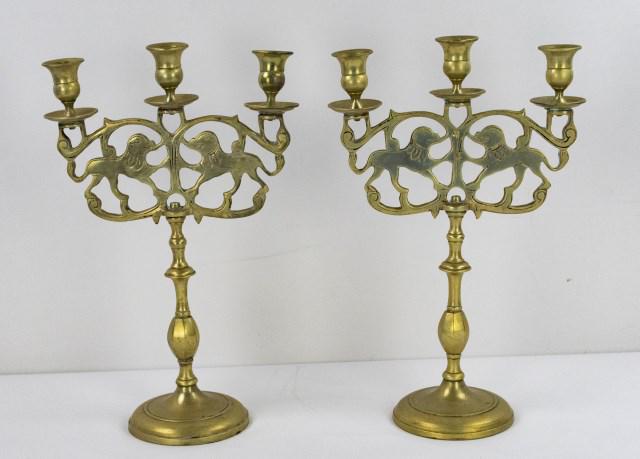 Pr. Heavy Brass Lion of Judah Shabbat Candelabra: Each with three candle cups above two facing lions in a scrolled openwork frame, screw-on junctions, turned shaft on circular base, probably Poland, late 19th/early 20th century; 9"W, 14"H; good condi