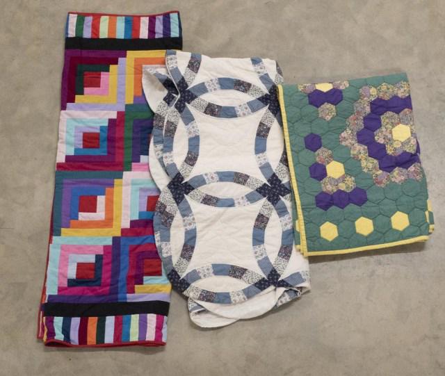 3 American 20th C. Handcrafted Quilts: 1. Wedding Ring design; 84" x 80 1/2"---2. Log Cabin design; 78" x 56"---3. Flower Garden design; 83" x 55 1/2"---all in good condition (Ref. 148, 289)