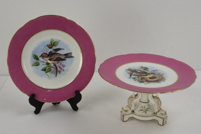 19th C. Porcelain Tazza w/ Dolphin Legs & Plate: Two items: Porcelain tazza, top with 1 1/2" pink band at shaped rim, center hand painted with a bird and floral and foliate decoration, raised on a tripod base having dolphin legs, all with gilt highl