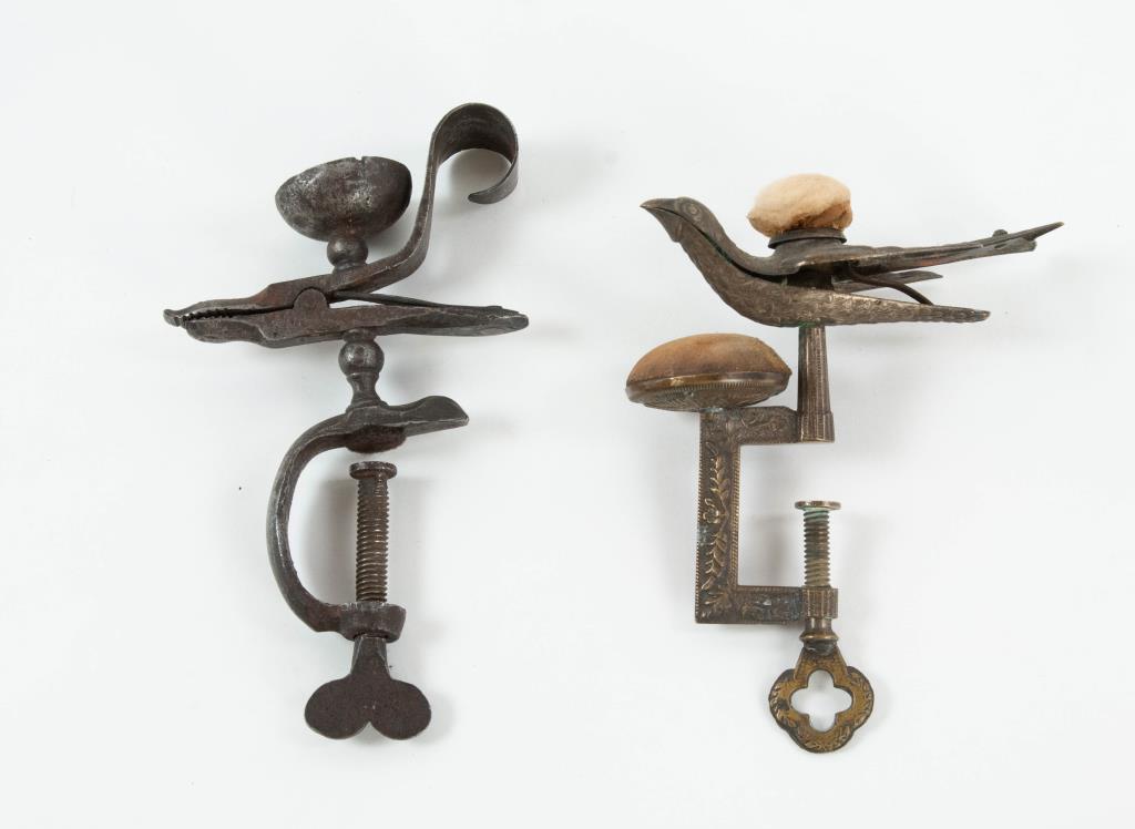 Iron Animal-Form & Waterman's Bird Sewing Clamps: Early iron animal-form sewing clamp having a snout, eyes and scrolled tail; holder for pin cushion on top, clamp with heart-shaped thumbwheel; 3 1/4"W---Waterman's brass sewing bird table top clamp, s