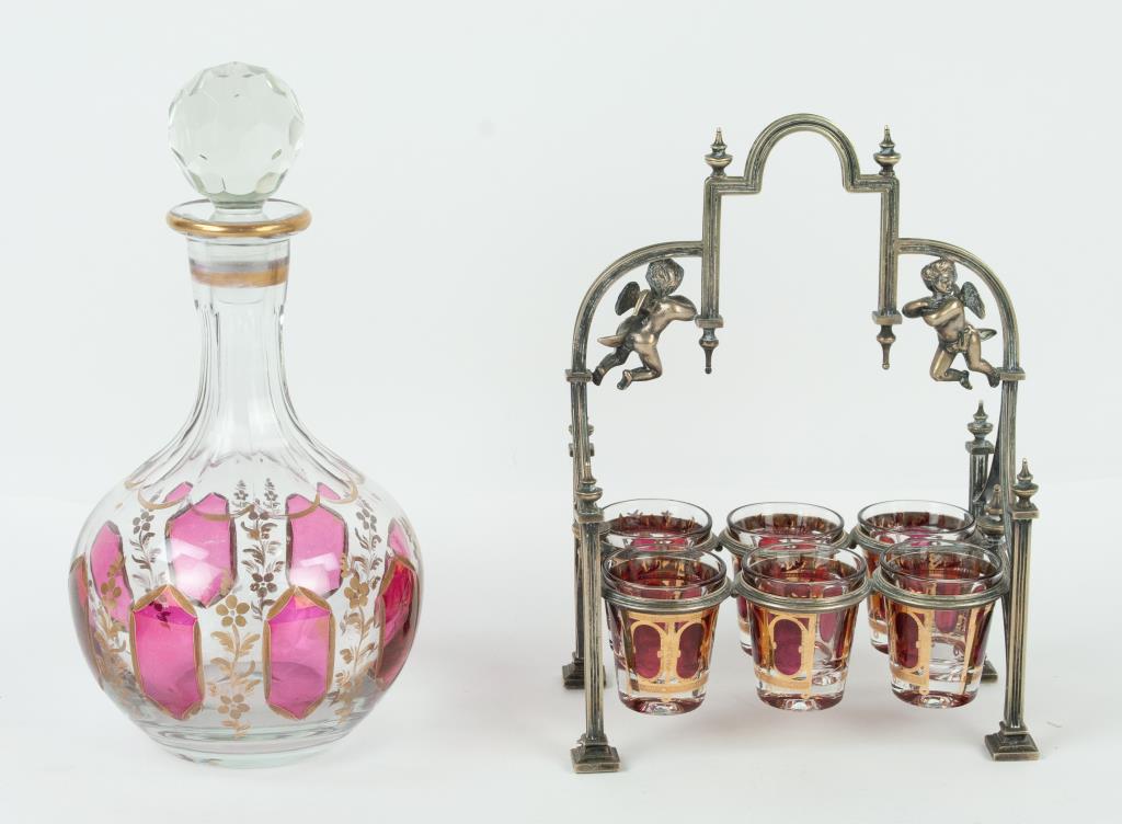 Gothic Style Communion Set w/ Decanter: Late 19th/early 20th century, Gothic style silverplate frame having two winged putti and decorated with arches and urn finials, holding six glass communion cups decorated with oval cranberry panels wi