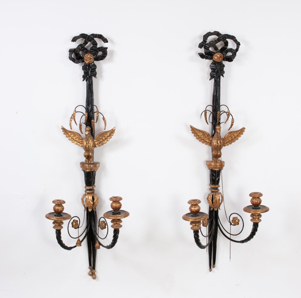 Pair of Large Italian Eagle Sconces: Early 20th century, pair of carved ebonized and gilt wood and metal candle wall sconces, Federal / Neoclassical style, tied bow pediment, a spread-winged eagle perched at center and having tassels han