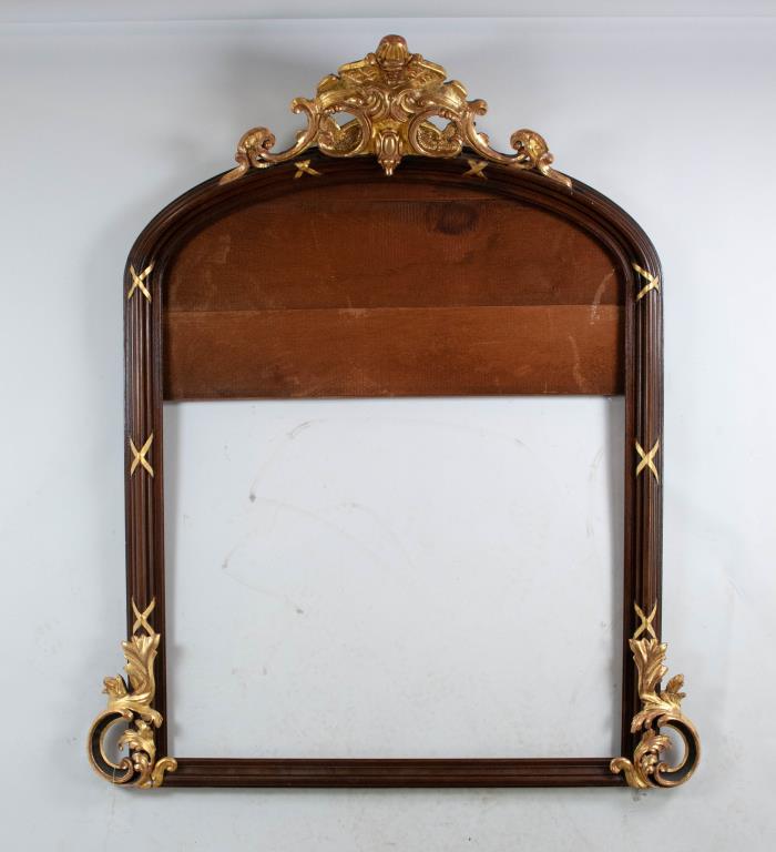 American Renaissance Revival Overmantel Mirror: Parcel-gilt walnut overmantel mirror, third quarter 19th century, the top of arched form with a carved gilt wood and gesso pierced projecting crest, deeply molded walnut frame with applied gilt metal 