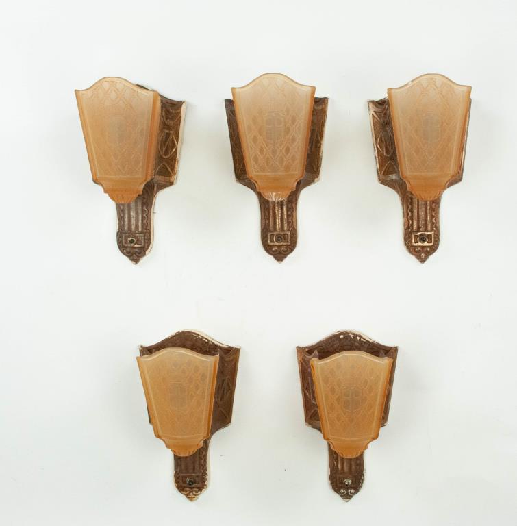 Set of 5 Art Deco Moe Bridges Wall Sconces: Set of five Art Deco wall sconces, cast iron plates with oak leaves and acorn crest, amber glass slip shades having a centered crown and shield decoration on a lattice ground on front and sides, crown