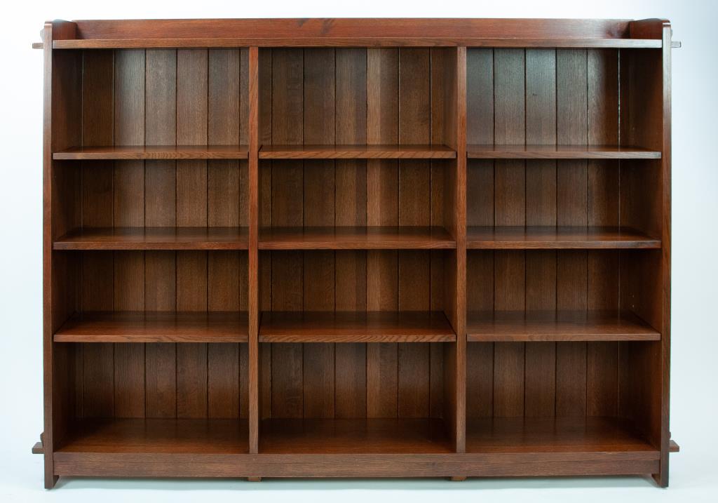 Stickley Audi Arts & Crafts Style Oak Bookcase: No. 89-648, open triple bookcase, tongue and groove back, adjustable top and bottom shelves, fixed middle shelf, branded mark and metal tag; 76 1/2"W, 12"D, 55"H; good condition with minor abrasions c