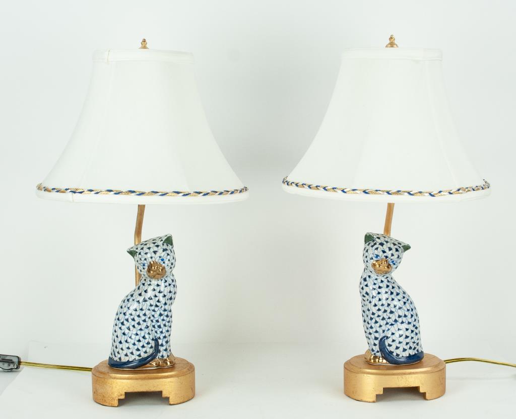 Pr. Frederick Cooper Fishnet Porcelain Table Lamps: Pair of porcelain cat lamps hand painted with blue fishnet motif, mounted on molded gilt base, shade with blue/white/gold braided trim, labeled on socket and on shade; 19 3/4"H to top of finial; some