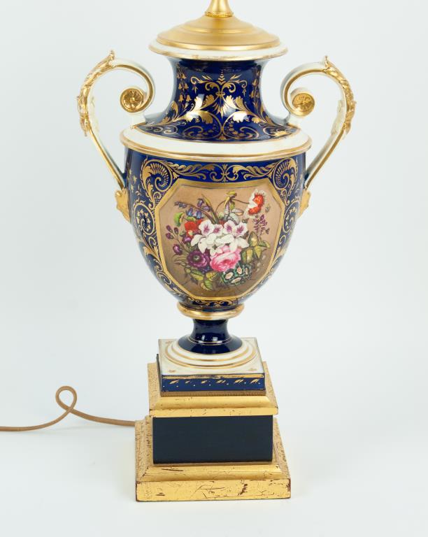 Meissen Porcelain Vase Lamp: Urn form vase with hand painted floral panel to front, cobalt ground with elaborate gilt scrolls and floral and foliate accents, scroll handles accented with gilt acanthus leaves and mask terminals, p