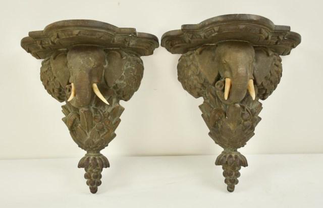 Pair of Elephant Figural Wall Brackets: Composite, each with shaped shelf having a support in the form of an elephan't's head with tusks and with foliates and fruits surrounding, 20th century; 10 5/8"W, 6"D, 11 5/8"H; one tusk replaced