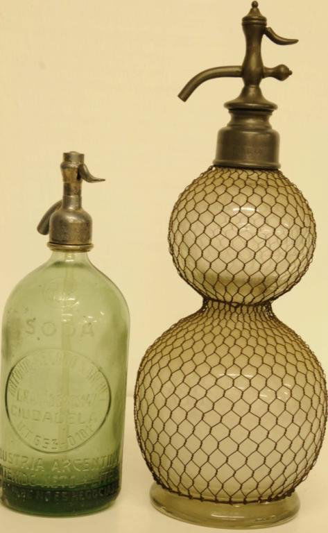 Two Vintage Soda/Seltzer Siphon Bottles 1. French: Two Vintage Soda/Seltzer Siphon Bottles 1. French clear glass double bulbous shaped siphon bottle with fitted, metal netting and having a pewter spout; bottom with ground and polished pontil; inscribe