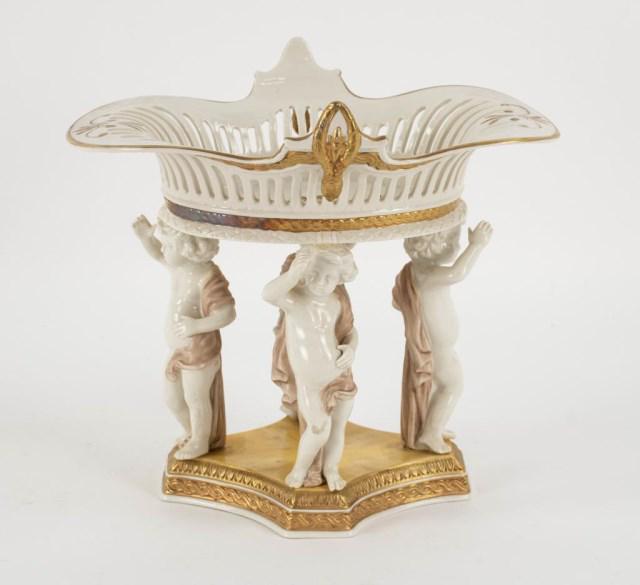 Chelsea House Italian Porcelain Centerpiece: Chelsea House figural centerpiece, four putti standing on a marbleized quadripartite base and supporting a flared reticulated bowl, marked on base "Porcelain / Italy / Chelsea House / Port Royal / Ita