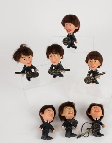 Seven 1964 Beatles Dolls by NEMS Seltaeb: Seven 4 1/2"H dolls made by NEMS Seltaeb, Inc., c. 1964, comprising: Two Paul McCartney, both with guitar; Two John Lennon, one with guitar; One George Harrison with guitar; Two Ringo Starr, both with