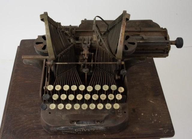 Oliver No. 3 Typewriter on Work Table: c. 1900-1907, Oliver Standard Visible Writer No. 3; The Oliver Typewriter Co., Chicago; approx. 13 1/2"W, 10"H, 14"D; needs cleaning, small piece broken off on one end of space bar, working condition