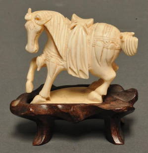Chinese Carved Ivory Figure of Horse: Depicting saddled figure of horse standing with one raised leg; fitted with wooden base; 3 1/4"H including base; chip to one ear
