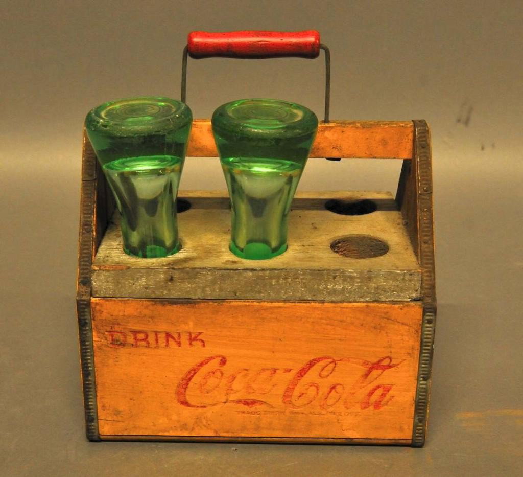 Two Old Soda Syrup Bottles & Wood Coca-Cola Case: Two early Coca-Cola syrup bottles in a c. 1941 Coca-Cola wings wooden carrier that has been adapted to hold six syrup bottles; bottles 7 3/4"L, 2 1/4" bottom diameter; carrier 8" x 5 1/2", 7 1/2"H; on