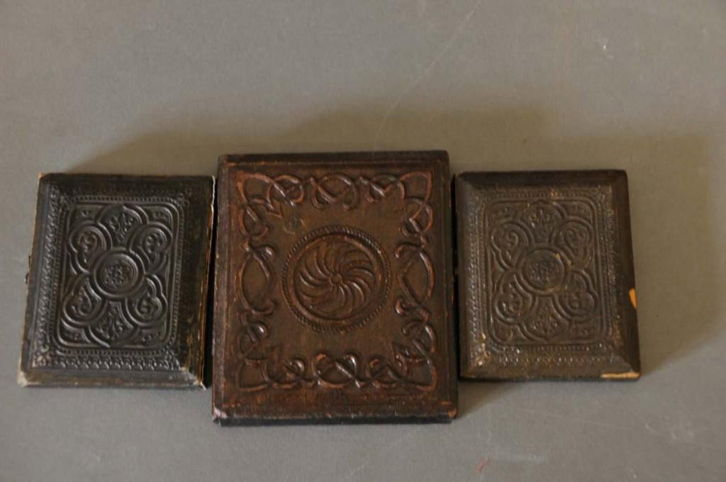 Three Ambrotypes with Union Cases: 1. Black sixth plate Union Case with portrait of mother and daughter, daughter is holding a cased daguerreotype or ambrotype portrait of man which is probably the deceased husband/father; 2. Black six