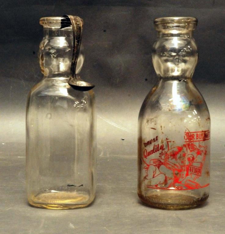 2 Baby Face Quart Milk Bottles, 1 Cream Top Spoon: 1. Baby face painted quart milk bottle; clear glass embossed "Mass T Seal" for Thatcher Manufacturing Co. and also embossed "Baby Top Patent Design No. 98609/Registered"; approximately half of red pyr