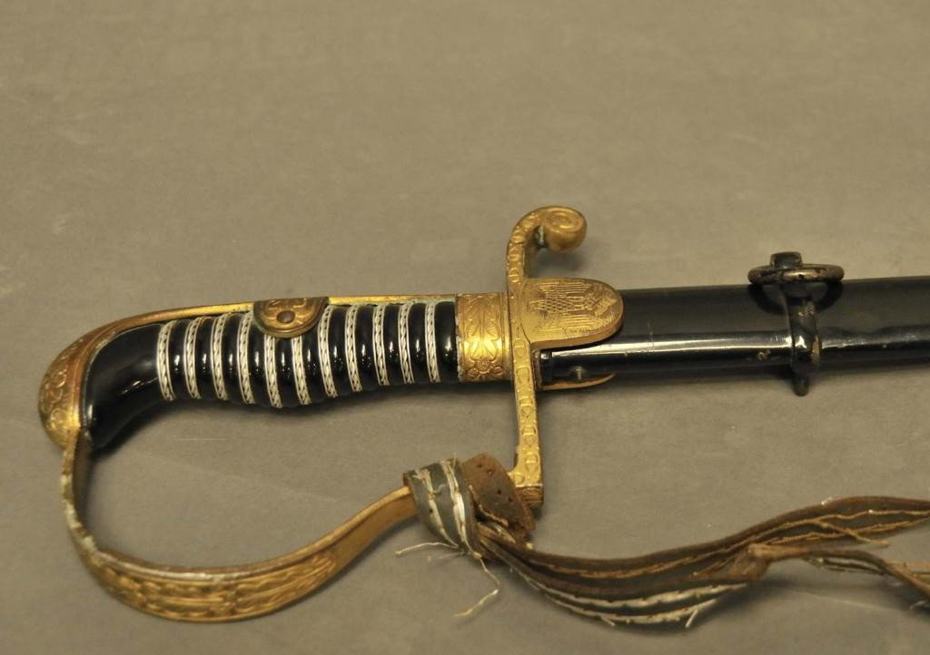 WWII German Eickhorn Army Roon Pattern Sword: 33 1/2" fullered blade marked "Original Eickhorn Solingen" with squirrel trademark; black celluloid grip with central bulge and triple aluminum wire wrap, the center being twisted; gilt hilt with exte