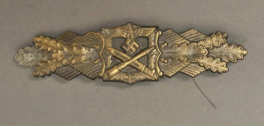 German Nazi Close Combat Clasp in Bronze: Center having eagle with outstretched wings clutching a swastika positioned above a crossed bayonet and grenade flanked by oak leaves and acorns; back embossed "F.E.C.W.E. Peekhaus Berlin" and "JFS" w