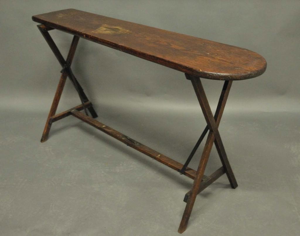 Dressmaker's or Tailor's Wooden Ironing Board: Two pieces consisting of wooden ironing board on hand wrought metal and wood stand; 32"H, 19 1/2"D at base; ironing board 56 1/4"L, 14 3/4"W