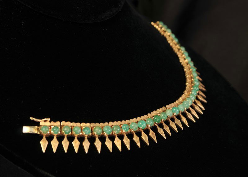 Vintage 14 kt. Yellow Gold Emerald Bracelet: Link style bracelet with 36 round cabochon cut emeralds weighing approx. .50 carat each; each stone with a textured "M" shape design on one side, a textured spear shape on the other; hidden box style