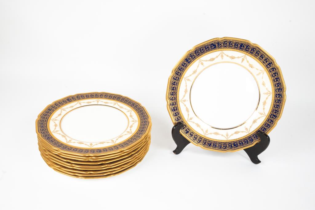 Ten Royal Doulton Porcelain Dinner Plates: Decorated with gilt banding and raised gilt florals and beading on a cobalt band; cavetto with gilt floral swags accented with beading; ivory ground; retailed by The Kinney & Levan Co., Cleveland, Ohi
