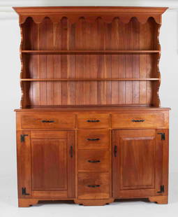 Two-Piece Cherry Pewter Cupboard: Bench made, 20th century, upper section with cove-molded cornice above a scalloped frieze and scalloped sides set with two fixed shelves, lower section with rectangular top having a molded edge, three