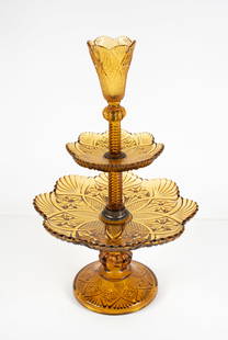 Amber Glass Dessert Epergne: Amber pressed glass dessert epergne having a central cup at top over two tiers; round foot; cup and each tier with scalloped fan rim, eight-pointed stars and diamonds; 11"W, 17 1/2"H---From the estate