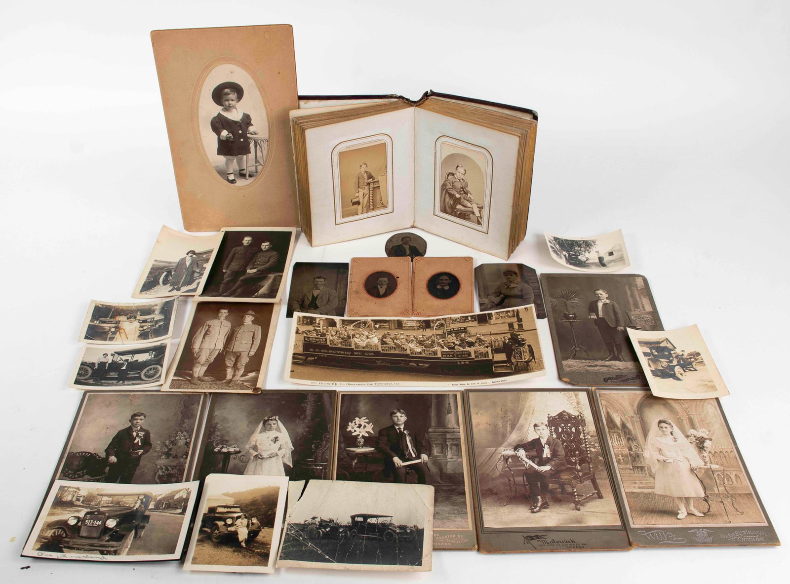 Early Photo Album and Other Early Photographs: Early photo album with 49 late 19th / early 20th century black and white photographs of men, women and children (majority of children); latch missing on album---Eight small various black and white pho