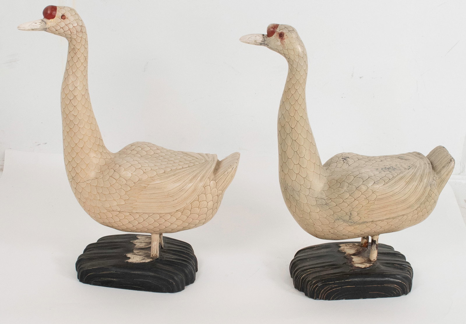 Pair Carved and Painted Chinese Geese: Pair of life-size carved Chinese knob geese, polychrome and gilt paint decorated with overall feather detail, beaks probably bone, mounted on carved wood bases, unmarked; approx. 20"L, 8"W, 26"H; good