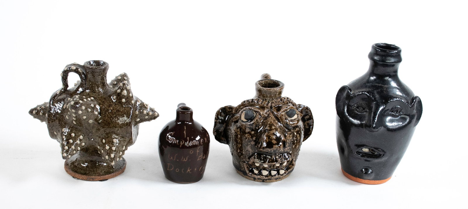 4 Pcs. of North Carolina Folk Pottery: 1. Michael Ball miniature jug or runlet with spout and applied handle, molded overall with projecting points decorated with white slip dots, unmarked; 4 3/8"H, 5"W---2. Ed Lane miniature face jug; mol