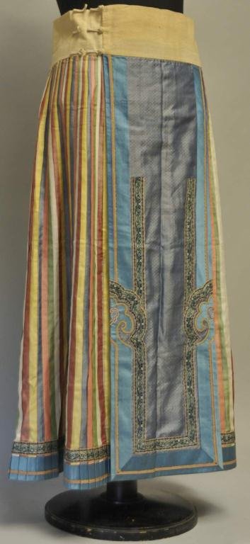 Chinese Embroidered Silk Skirt (Qun): Hand sewn skirt with flat decorated panels at center front and back, flanked on both sides by pleated panels of varying colors, embroidered trim, blue silk damask borders and hem, cotton waistband; la