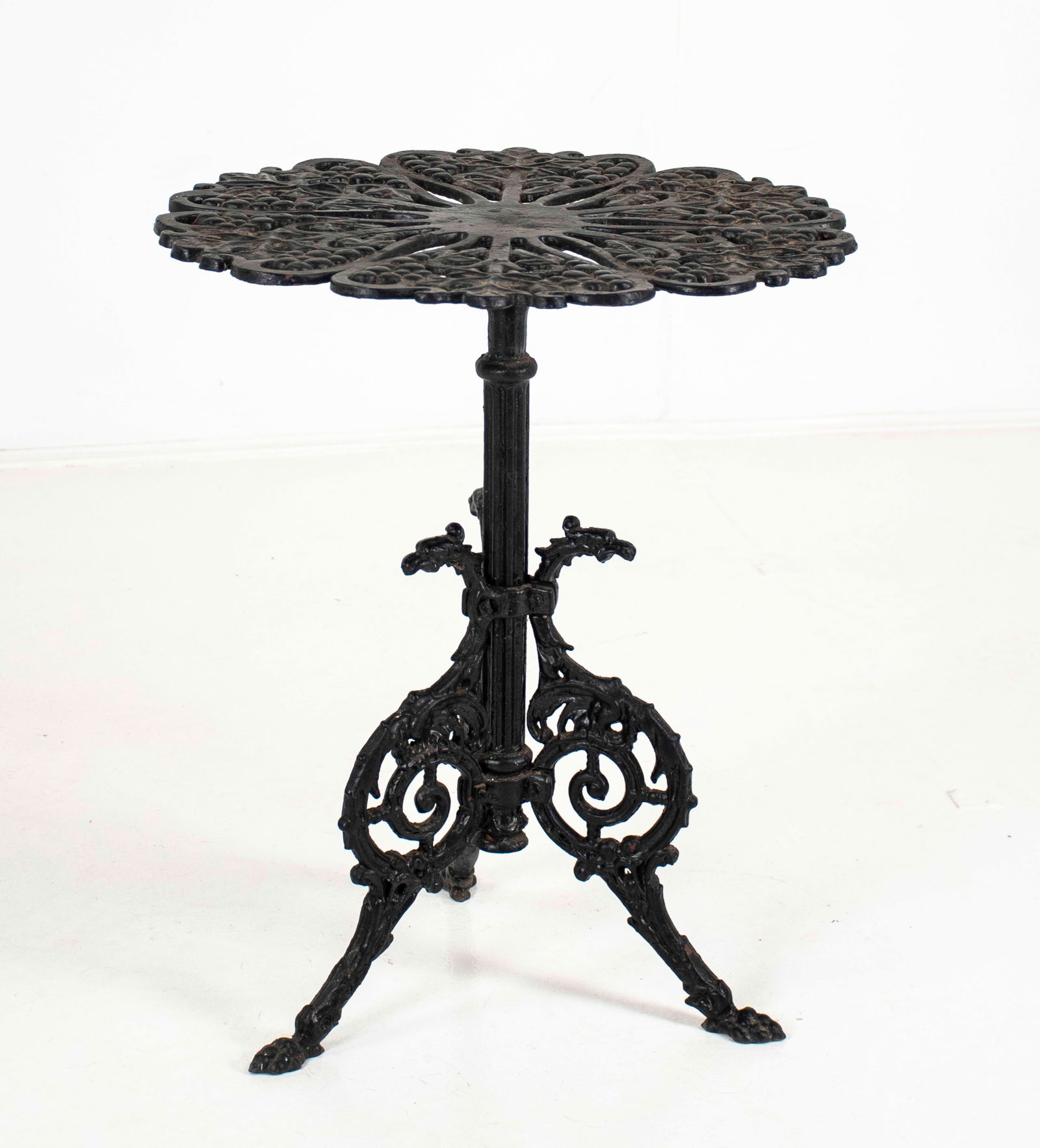 Victorian-Style Winged Griffin Cast Iron Table: Painted black cast iron occasional table having a scalloped and pierced circular top over a winged griffin tripodal base, early 20th century; 20" dia., 24"H; good condition