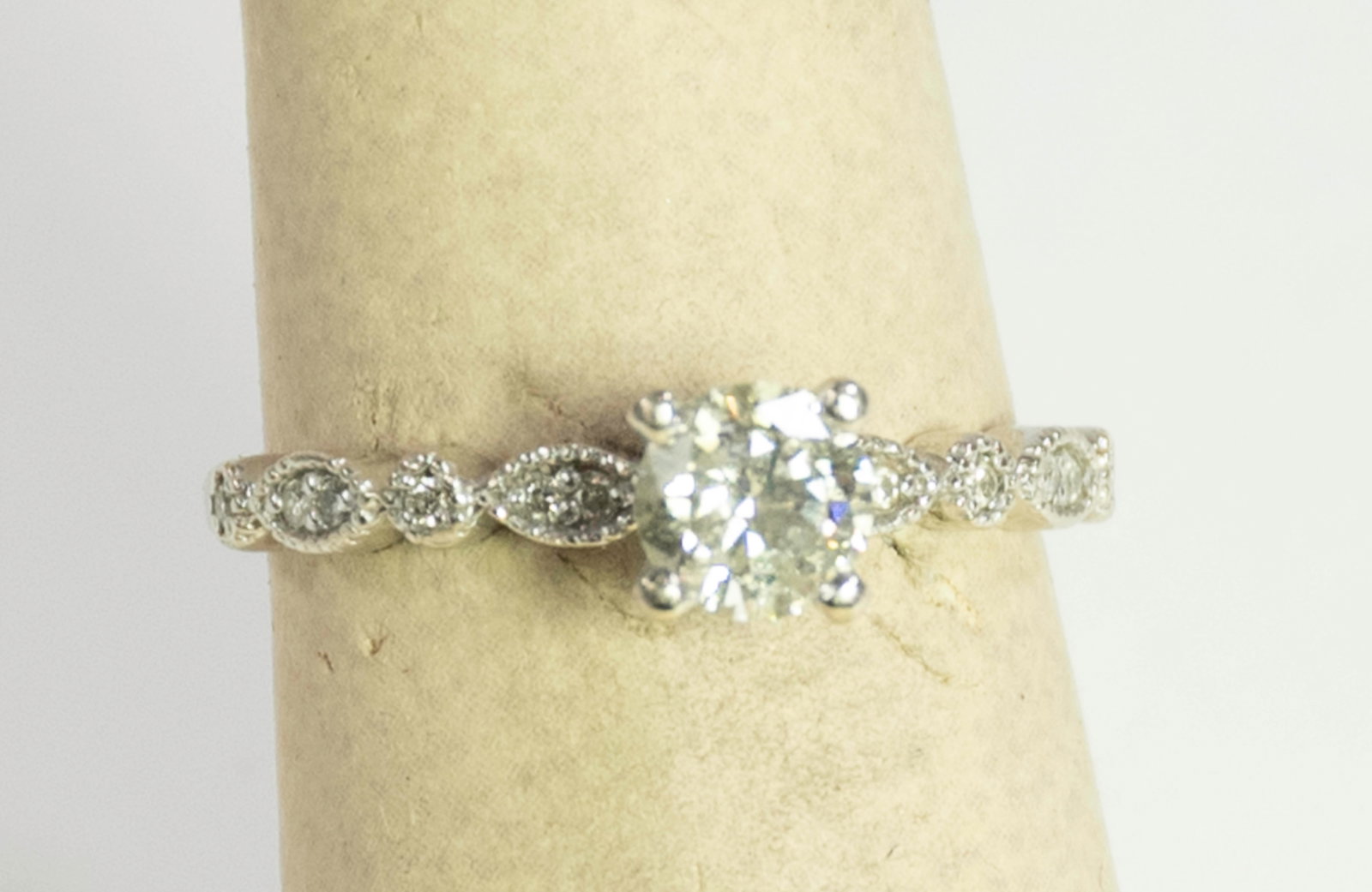 Diamond and 14K Ring: Approx. .60 carat diamond, clarity I-2, color J-K, with eight accent diamonds on band, mounted in stamped "14K" white gold; size 7---total weight 2.53 grams