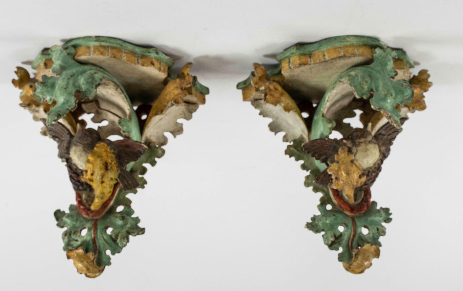 Pr. Small Italian Painted Wood Bracket Shelves: Pair of facing small carved and painted wood bracket shelves; each having a shaped shelf over pierced backplate with a bird amidst scrolling leaves; leaves painted yellow and green, birds brown and