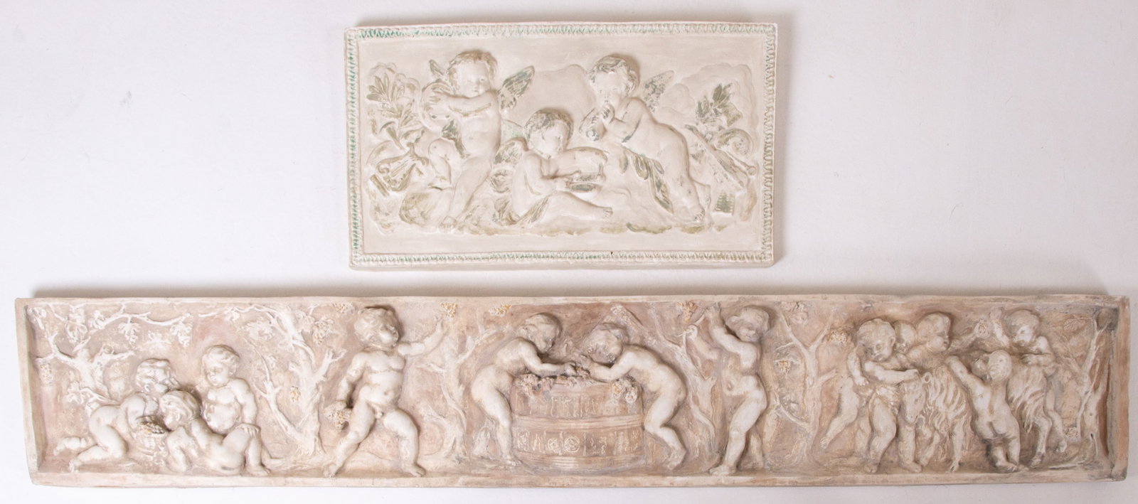 2 Neoclassical Style Cast Plaster Relief Plaques: 1. Twelve putti engaged in various activities involving winemaking; 8"H, 47"W---2. Three cherubs playing musical instruments; 9 3/4"H,, 17 1/2"W; good condition with minor losses---This lot does not