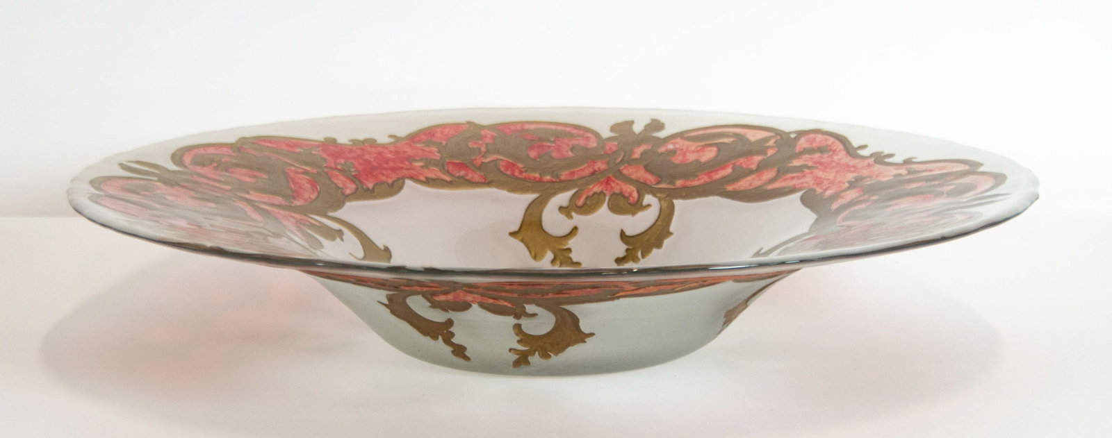 Versace Style Opaque Glass Centerpiece Bowl: Qualifies for in-house shipping---Opaque glass centerpiece bowl with a scrolling gilt and red wreath around outer rim and a gold rosette medallion at center 18 1/2"dia., 3 1/2"H; good condition---From