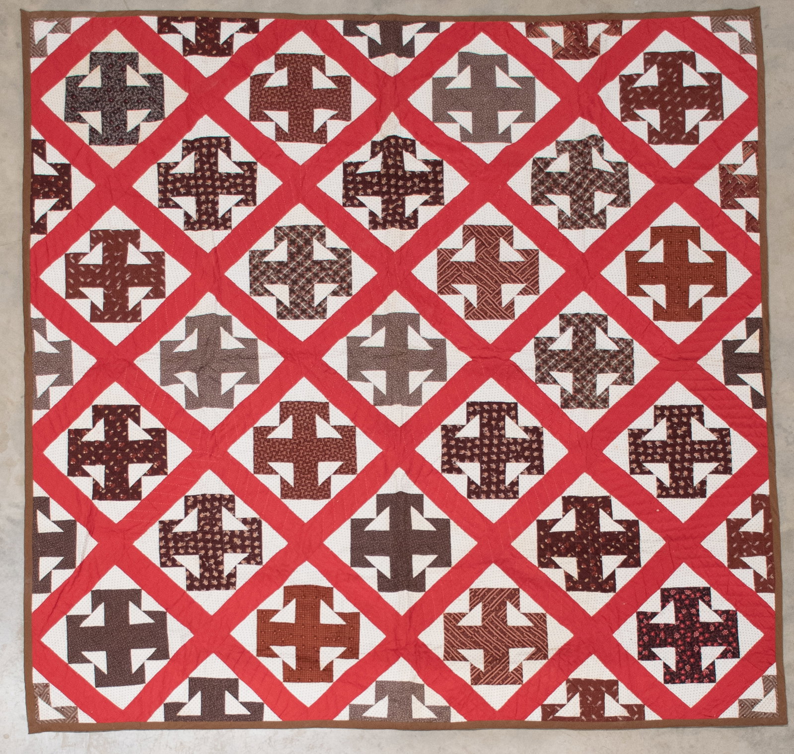 American Pieced Double T Pattern Quilt: Qualifies for in-house shipping---Early 20th century; each block having a pieced "Double T" in brown pattern fabric on a black and white polka dot pieced ground; solid red sashing; brown outer
