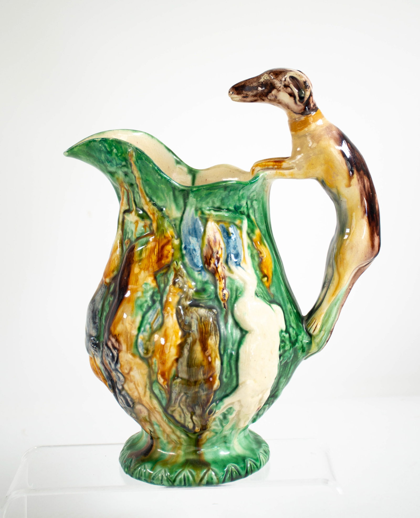 Majolica Game Pitcher w/ Hound Handle: Qualifies for in-house shipping---19th century, polychrome decoration, sides with hanging game in relief, hound handle, unmarked; 10"H; professional repair to interior of spout shows under blacklight