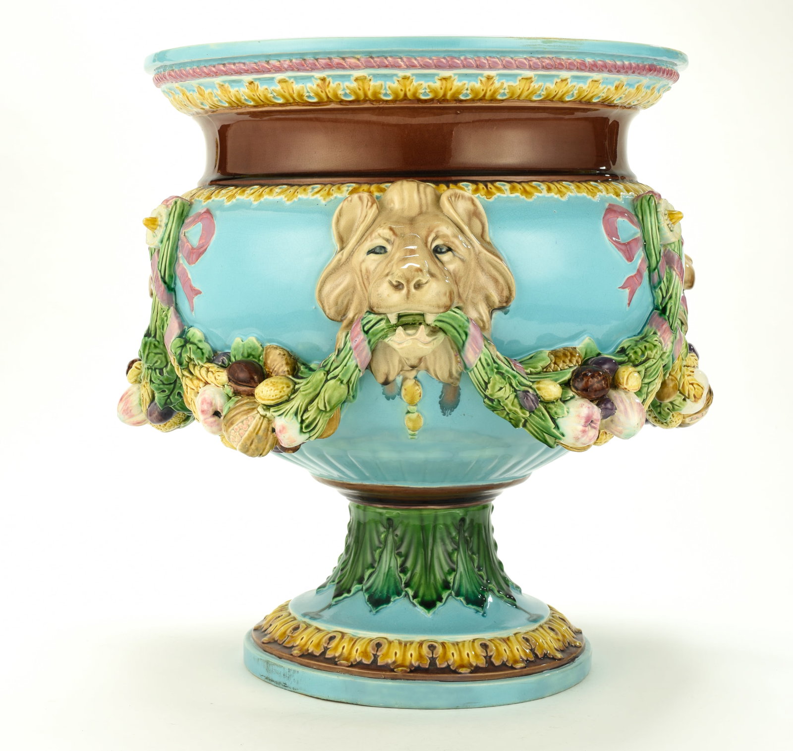 Minton Majolica Pedestal Jardiniere: Qualifies for in-house shipping---Urn-form jardiniere featuring a turquoise ground with high-relief molded lion masks connected by heavy pink beribboned swags of fruits and nuts, dark brown upper neck