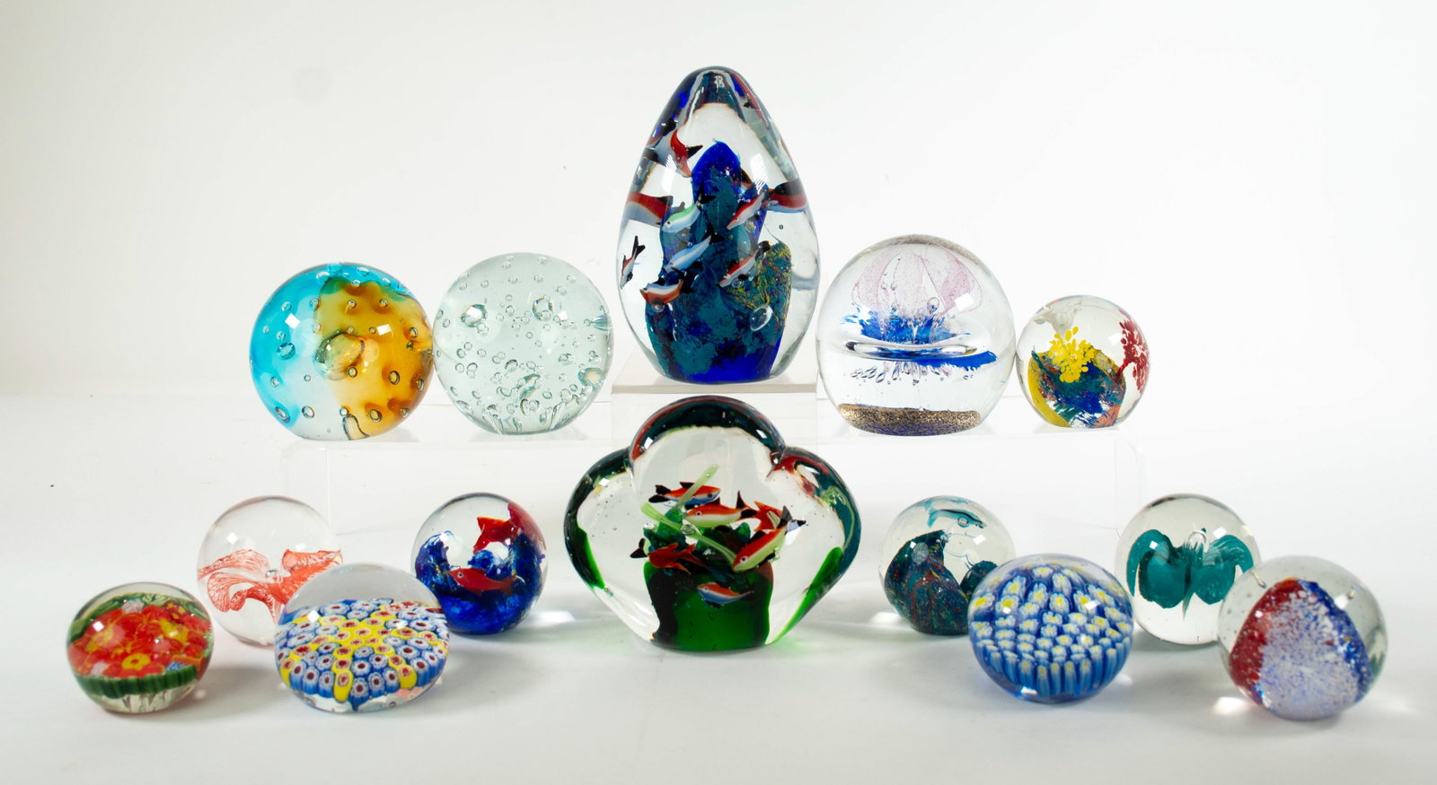14 Unsigned Art Glass Paperweights: Qualifies for in-house shipping---Two millefiori; one in red, blue, yellow and white; one in blue, yellow and white---Four depictiing an encased aquarium scene with colorful fish---Ball form with