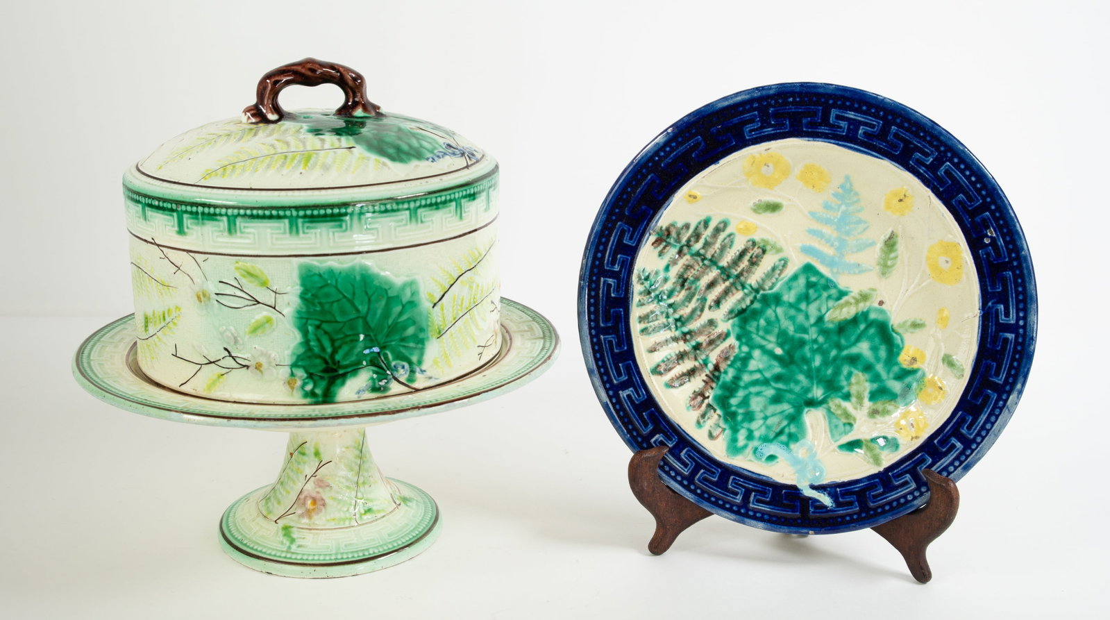 Majolica Leaf & Fern Cheese Keeper Stand & Plate: Qualifies for in-house shipping---Each having leaf, fern and floral decoration with Greek key border: Cheese keeper with a domed cover on pedestal stand; green, yellow / green and light pink