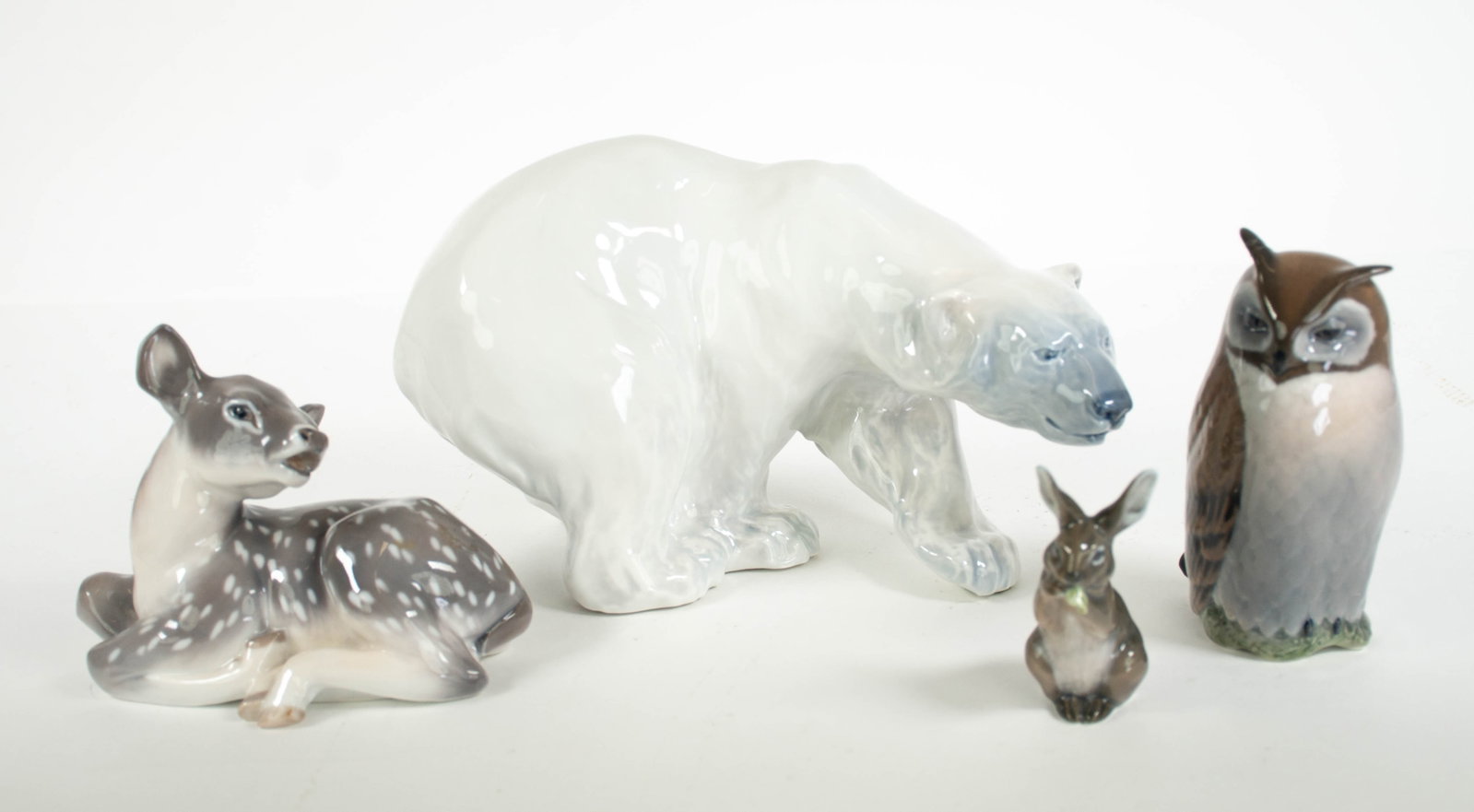 4 Royal Copenhagen Porcelain Animal Figures: Qualifies for in-house shipping---1. Polar bear, model number 1137; approx. 10 1/2"L, 6 3/4"H---2. Rabbit sitting and eating lettuce, model number 1019; approx. 3 5/8"H---3. Recumbent deer, model