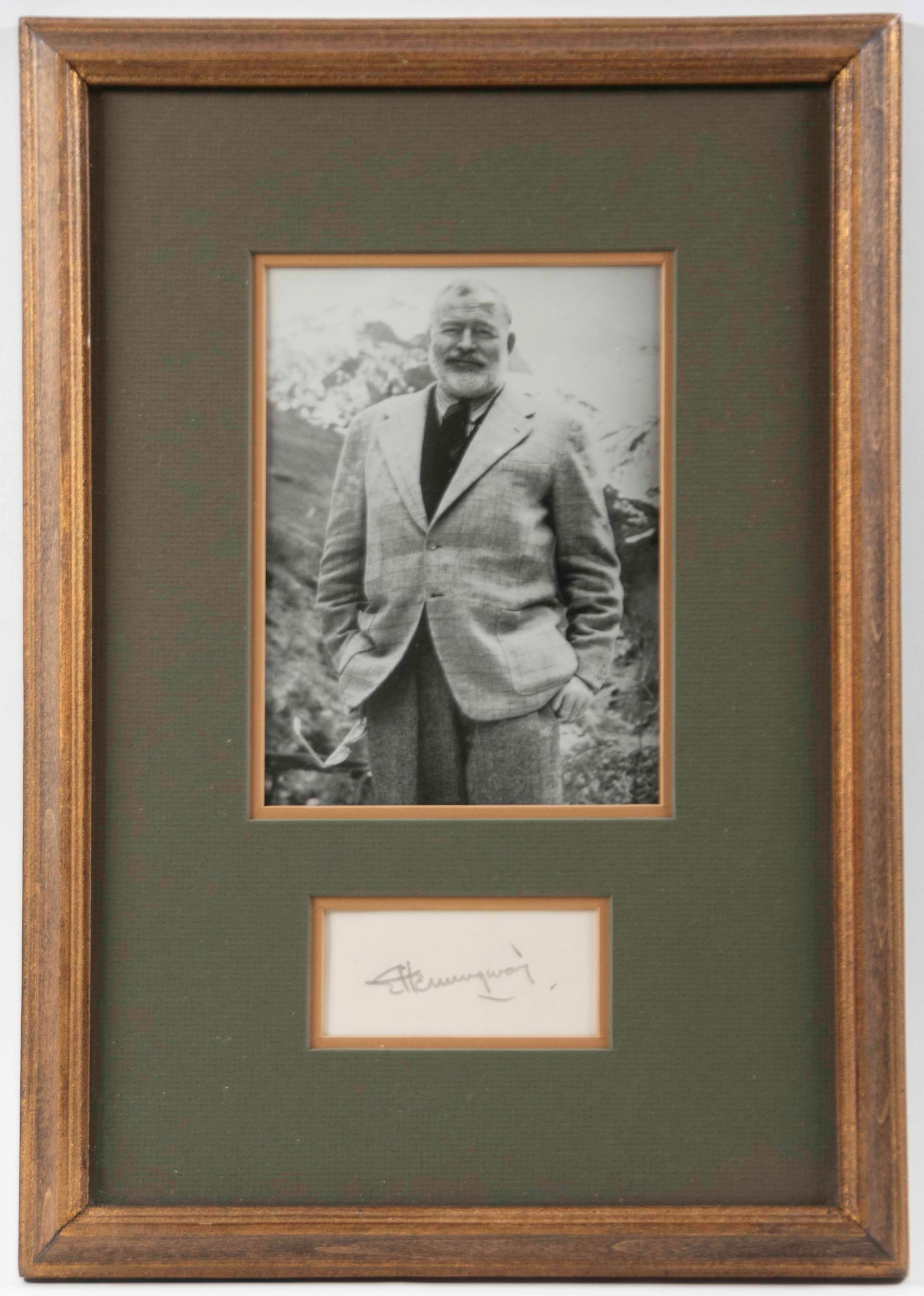 Ernest Hemingway Signature w/ Portrait: Qualifies for in-house shipping---Signature in pencil beneath a black and white printed portrait, both double matted and under glass in a gilt wood frame; 15" x 10 1/2"; good condition (Inv. 13)