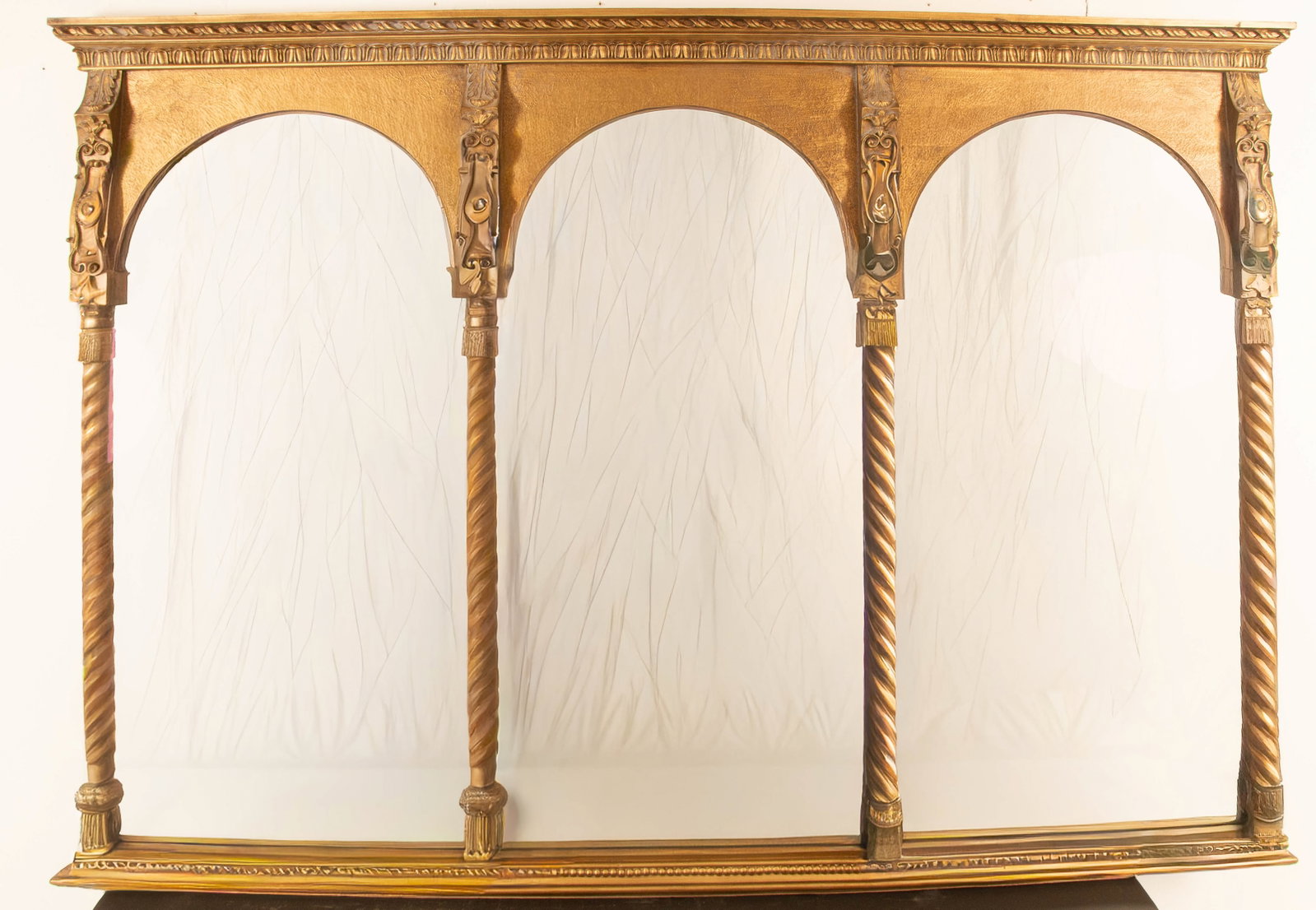 Giltwood Triptych Mirror: Carved cornice over three arched mirrors framed with ornate carved acanthus, scroll and rope-twist columns; 20th century; 46"H, 67"W, 2 3/4"D; good condition---This lot does not qualify for in-house