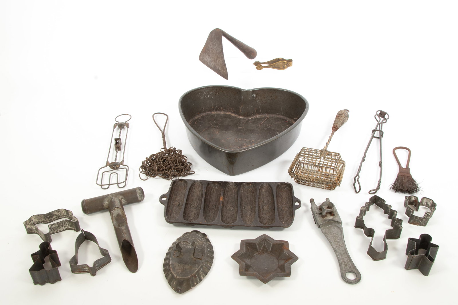 Iron Dough Scraper, Other Metal Kitchen Items: Qualifies for in-house shipping---Iron dough scraper, triangular blade with angled hollow conical handle; 4"L, 4 1/2"W--- Hamlinite tin vegetable peeler, Pat. Jul 20-20--- Cast iron corn stick pan, ma