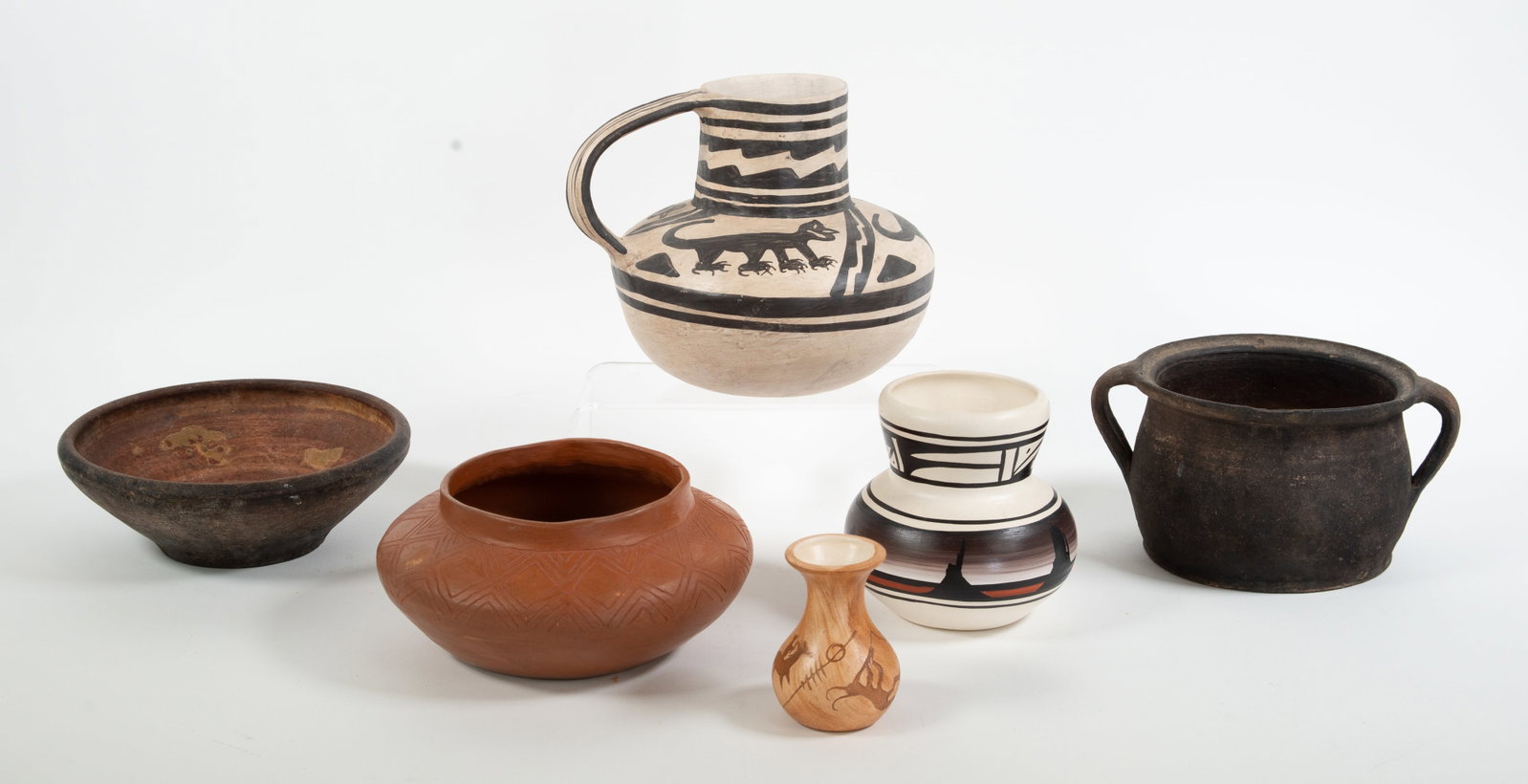 Anasazi, Navajo, Other Southwestern Pottery: Water jug with handle, black on white with painted designs of animals and decorative banding, incised on base "Anasazi / ? 89 / Blushing Meadow / Vase"; 6 1/2"H, 7 3/4"W; good condition---Small signed