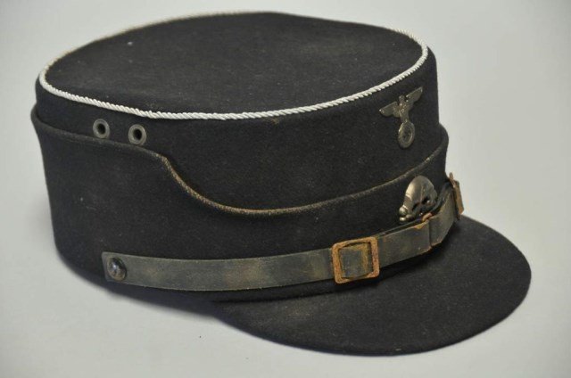 German WWII Nazi SS Officer's Coffee Can Kepi: Black wool with silver piping, SS eagle and jawless Totenkopf insignia; interior crown stamped "58" with the SS runes in a circle, black label under sweatband reading "Dom / Reichsfuhrer SS / befohlen