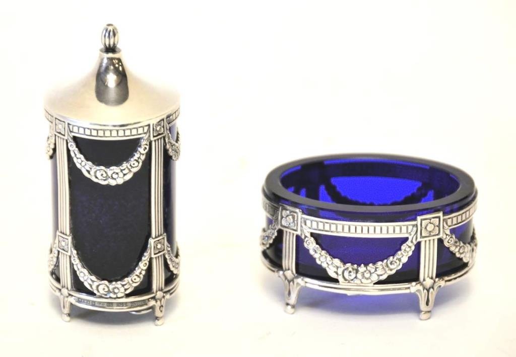 Sterling Salt Cellar & Pepperette: 20th century, Swedish, salt cellar and pepperette by Mema Guld & Silver AB, Lidkoping; in the Empire taste, the sterling silver frames embossed with reeded legs and floral swags and fitted with cobalt