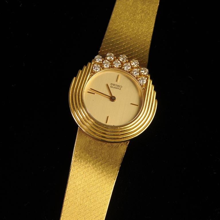18kt Gold & Diamond Seiko Watch: 18kt yellow gold Seiko lady's watch, set with eleven diamonds, estimated weight 1/2 ct total, marked on back "18kt / 790003 / 43-0199-D / Swiss Made Case", 1.955 ozt total weight